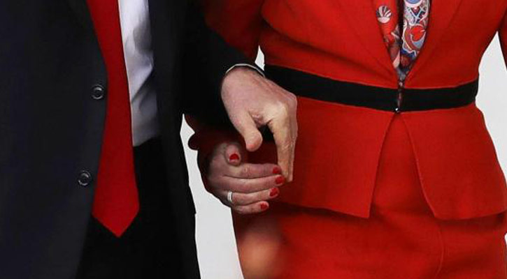 Trump holds Theresa May's hand during walkabou