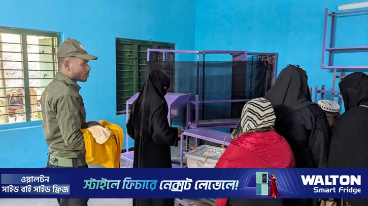 আনসার সদস্যের কোলে শিশুকে রেখে ভোট দিলেন মা